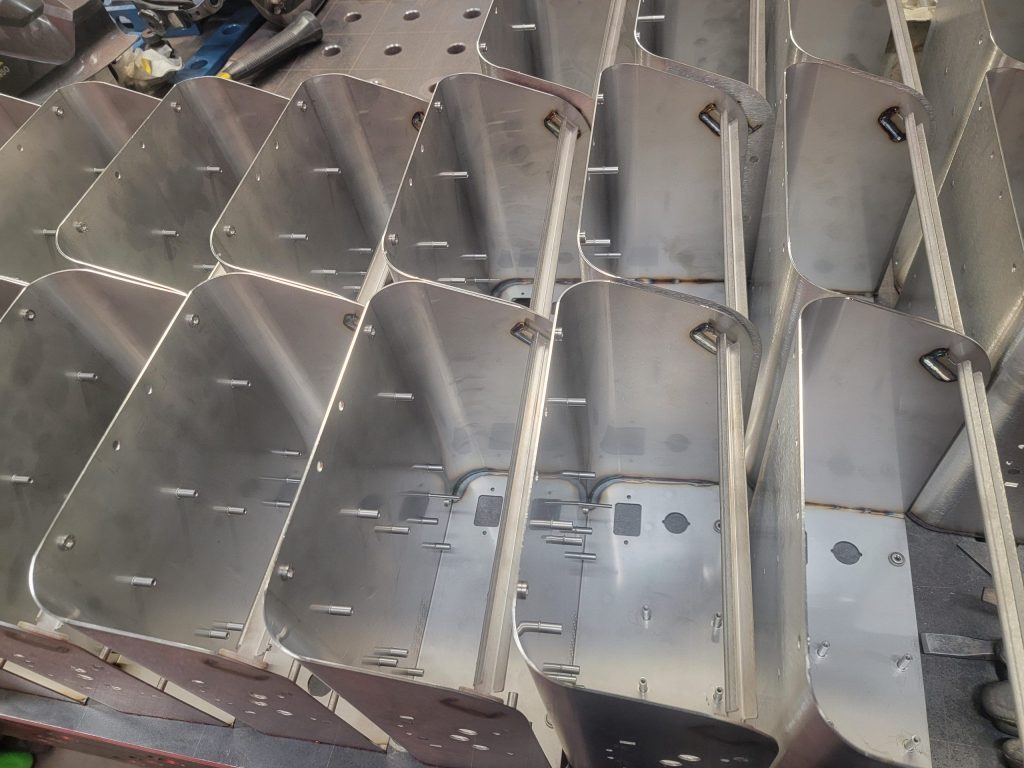 These electronics enclosures have welded supports, fasteners, large radius bends, and are ready for powder coating.