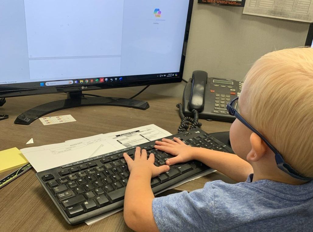 Image of child using computer at office desk